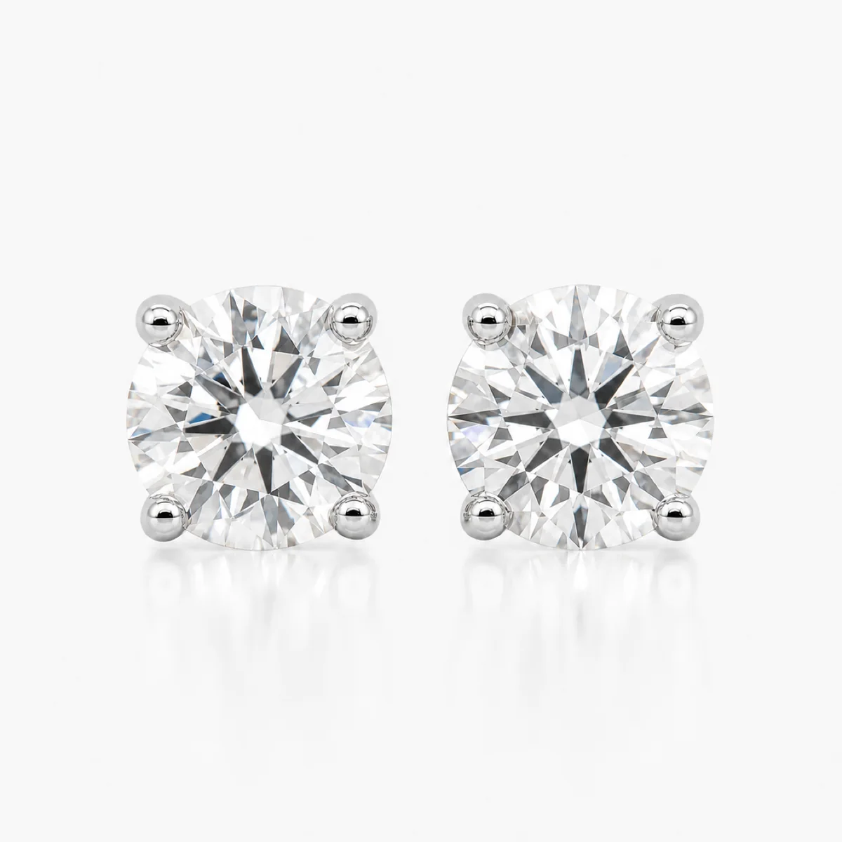 Four-claw studs diamond earrings in platinum, round diamond, made to order by Prodiam (rendered design reference)