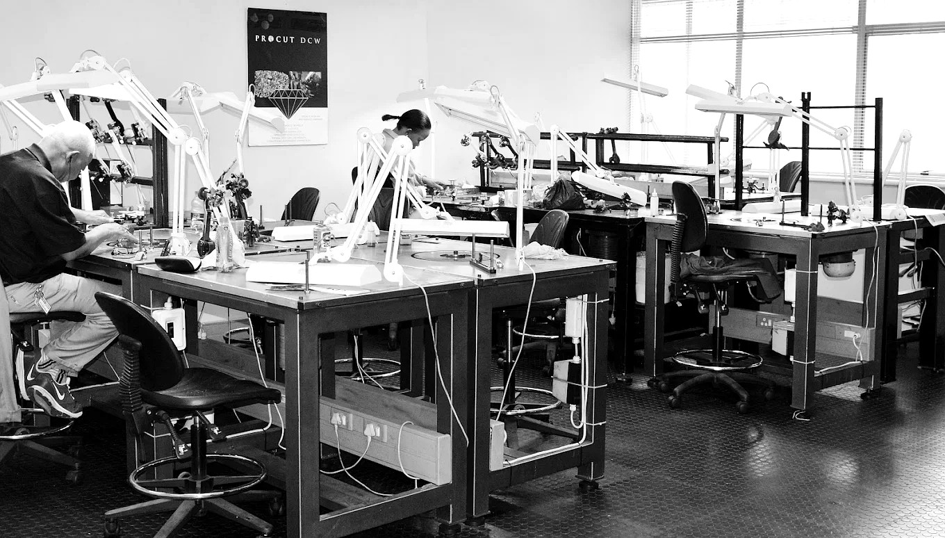 The Procut DCW diamond cutting workshop in Bedfordview, Johannesburg: polishing benches with anglepoise lamps and cutters at work under the Procut DCW poster