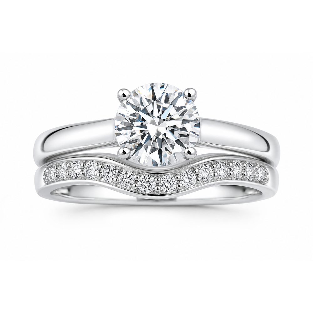A diamond bridal set: a solitaire engagement ring with a matching curved wedding band, designed to sit as one set.